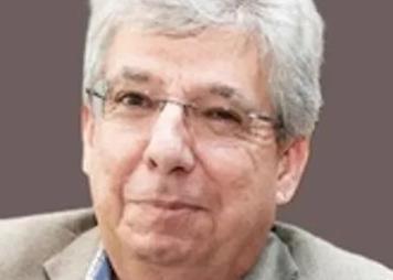 Picture of Dr. Warner in a tan jacket and plaid shirt. 